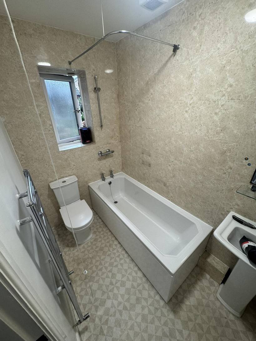 Before: Panelled bathroom to large tiles and copper brassware