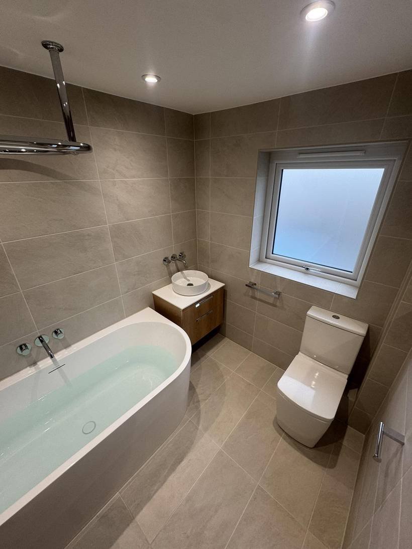 After: Family bathroom to wall-mounted taps and a curved bath, Aquafix Services Leeds