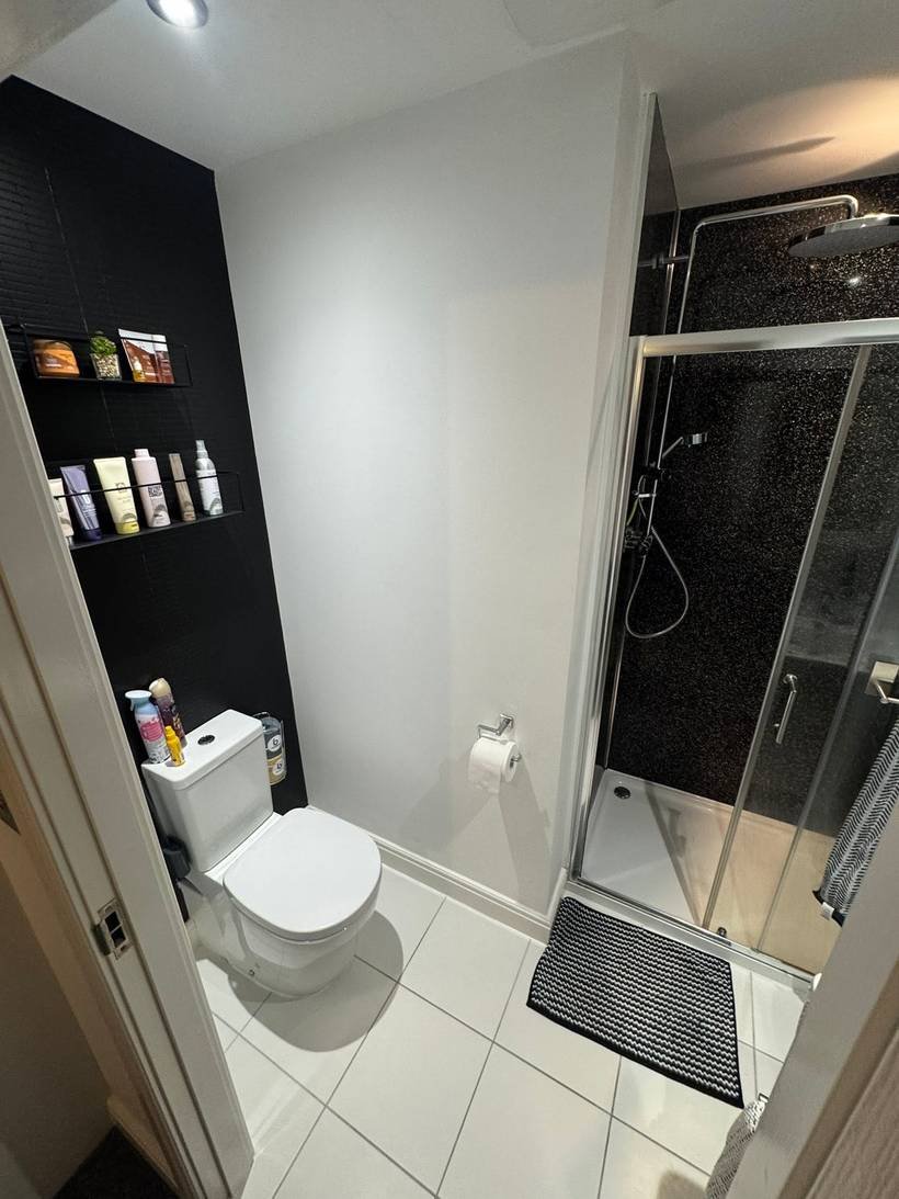 Before: Shower room to dark tiles and brushed brass